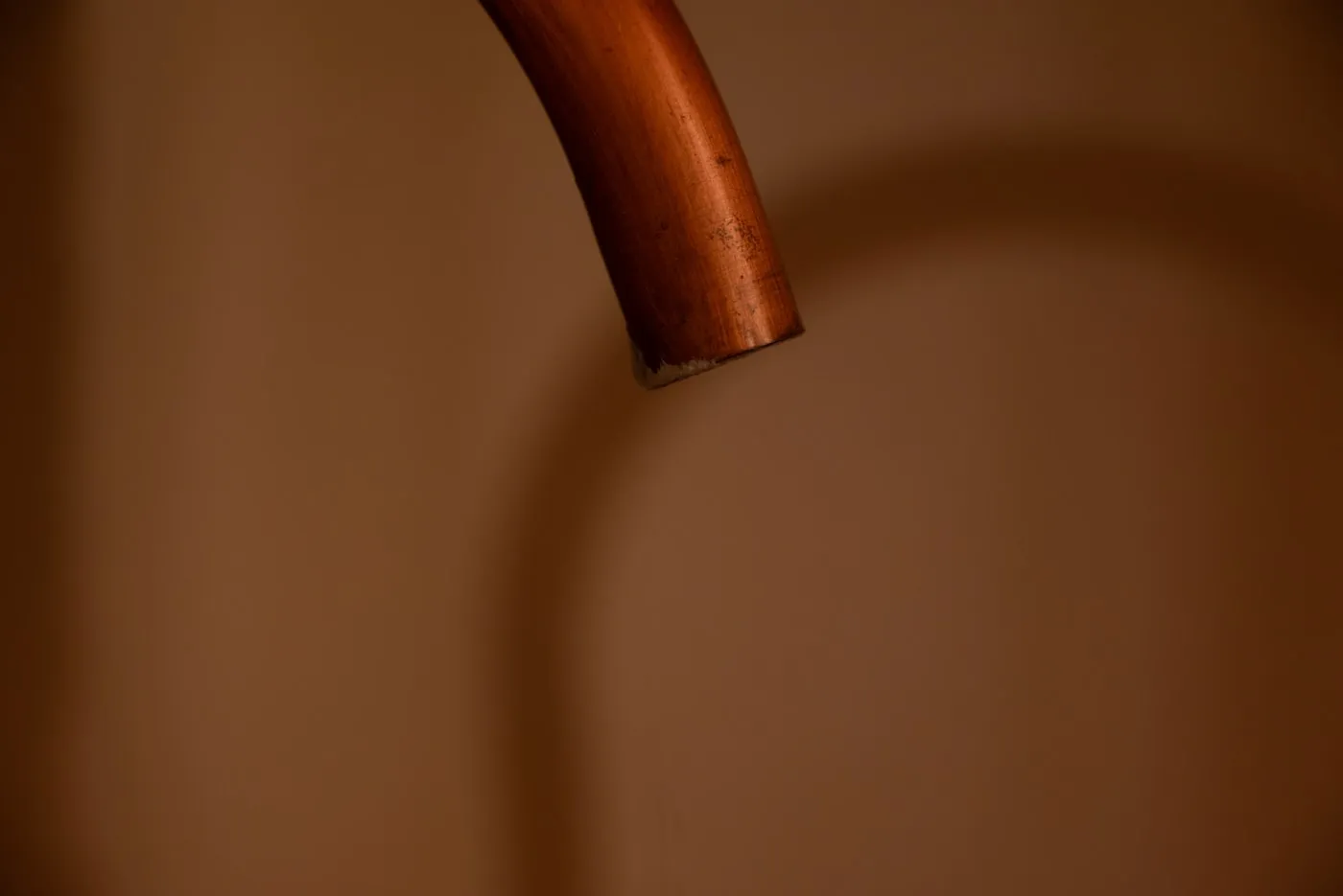 Tube de cuivre apparent en gros plan, lumière rasante